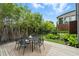 Outdoor dining area with a black table and chairs, wooden deck, and manicured landscaping at 1742 Temple Dr, Winter Park, FL 32789