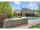 Outdoor kitchen and dining area with a pool and modern home in the background at 1742 Temple Dr, Winter Park, FL 32789