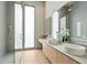 Modern bathroom features double sinks, large mirrors, wood cabinets, walk-in shower and large frosted window at 1742 Temple Dr, Winter Park, FL 32789