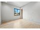 Simple bedroom with a view of the outside through a large window, natural light, and hardwood flooring at 1742 Temple Dr, Winter Park, FL 32789