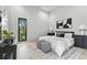 Minimalist bedroom design with a queen-sized bed, patterned ottomans, and view of greenery through a sleek, black window at 1742 Temple Dr, Winter Park, FL 32789