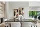 Modern dining room showcasing a dark wood table and gray chairs with a view of the pool and lush greenery at 1742 Temple Dr, Winter Park, FL 32789