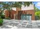 Modern home with a unique facade and multi-paned glass garage door, complemented by decorative driveway at 1742 Temple Dr, Winter Park, FL 32789