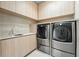 Well-organized laundry room featuring modern washer and dryer units, sleek countertops, and ample storage space at 1742 Temple Dr, Winter Park, FL 32789