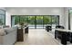 Large living room with hardwood floors, modern furniture, large windows and view of pool with bamboo at 1742 Temple Dr, Winter Park, FL 32789