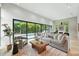 Bright living room with modern furniture, large windows and view of the pool with bamboo at 1742 Temple Dr, Winter Park, FL 32789