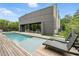 Modern home features a sleek pool, wooden deck, and gray exterior with large windows, perfect for luxury living at 1742 Temple Dr, Winter Park, FL 32789