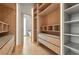 Custom walk-in closet with wood-look built-ins and shelving with marble countertop and light wood floor at 1742 Temple Dr, Winter Park, FL 32789