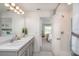 Well-lit bathroom featuring double sinks, neutral colors, and a shower with glass door at 214 Oak Lane Rd, Ocala, FL 34472