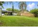 Large backyard featuring a covered patio, mature trees, and well-maintained grass, ideal for outdoor relaxation at 2154 Lake Christie Dr, Orlando, FL 32809
