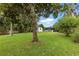 Expansive backyard features lush grass, mature trees, storage shed, and outdoor seating under a covered patio at 2154 Lake Christie Dr, Orlando, FL 32809