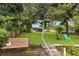 Serene backyard with lush lawn, mature trees, a bench, and colorful chairs, offering a peaceful outdoor retreat at 2154 Lake Christie Dr, Orlando, FL 32809