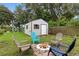 Landscaped backyard with a storage shed, fire pit, and seating area, perfect for enjoying the outdoors at 2154 Lake Christie Dr, Orlando, FL 32809