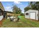 Backyard features a storage shed, fire pit, and covered outdoor seating area, creating a relaxing outdoor space at 2154 Lake Christie Dr, Orlando, FL 32809