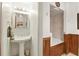 Bathroom featuring pedestal sink, mirror, and wood paneling around the bathtub at 2154 Lake Christie Dr, Orlando, FL 32809