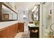 Bathroom with modern sink, wood paneling, large mirror, and shower at 2154 Lake Christie Dr, Orlando, FL 32809