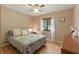 Cozy bedroom with a comfy bed, wood floors, a ceiling fan, and a sun-filled window for natural light at 2154 Lake Christie Dr, Orlando, FL 32809