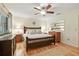 Comfortable bedroom with wood floors, ceiling fan, decorative mirror, and bedside lamps at 2154 Lake Christie Dr, Orlando, FL 32809