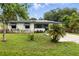This single-story home features solar panels, a well-manicured lawn, and a charming front porch at 2154 Lake Christie Dr, Orlando, FL 32809