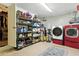 Organized laundry room featuring a red washer and dryer, storage shelves, and ample space at 2154 Lake Christie Dr, Orlando, FL 32809
