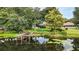 Picturesque waterfront view featuring a wooden dock surrounded by mature trees and lush greenery, perfect for nature lovers at 2154 Lake Christie Dr, Orlando, FL 32809