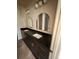 Bathroom featuring a double sink vanity with sleek black countertops and modern arched mirrors at 2352 Ross St, Kissimmee, FL 34744