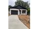 Charming single-story home featuring a garage, black trim, white stucco, and a concrete driveway at 2352 Ross St, Kissimmee, FL 34744