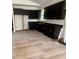 Modern kitchen featuring sleek black cabinets, countertops, and new wood flooring at 2352 Ross St, Kissimmee, FL 34744