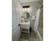 Updated bathroom features a modern vanity, a round mirror, and marble-look tiled walls at 2592 Grassy Point Dr # 106, Lake Mary, FL 32746