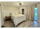 Bright bedroom features modern lighting, neutral tones, a large window, and wood-look flooring at 2592 Grassy Point Dr # 106, Lake Mary, FL 32746
