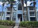 Inviting condo exterior features a light blue facade, multiple balconies, tropical palms, and lush greenery at 2592 Grassy Point Dr # 106, Lake Mary, FL 32746