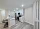 Modern kitchen featuring new stainless steel appliances, white cabinetry, breakfast bar, and wood-look flooring at 2592 Grassy Point Dr # 106, Lake Mary, FL 32746