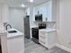 Well-lit kitchen features white cabinets, stainless steel appliances, sleek black hardware, and wood-look floors at 2592 Grassy Point Dr # 106, Lake Mary, FL 32746