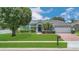 Charming single-story home with a well-manicured lawn, mature trees, and a brick driveway at 2674 Sugar Pine Run, Oviedo, FL 32765