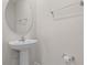 Bathroom featuring a pedestal sink and a round mirror with a towel rack at 275 Blueberry Ln, Davenport, FL 33837