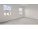 Bedroom with two windows with views of the neighborhood and soft carpeting at 275 Blueberry Ln, Davenport, FL 33837