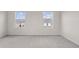 Spacious, carpeted bedroom featuring two windows with views of the neighborhood at 275 Blueberry Ln, Davenport, FL 33837