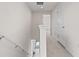 Upstairs hallway with carpeted floors, white bannister, and natural light at the bottom of the stairs at 275 Blueberry Ln, Davenport, FL 33837