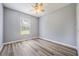 Well-lit bedroom with modern wood-look flooring, a window, and a ceiling fan for added comfort at 2767 Aragon Ter, Lake Mary, FL 32746