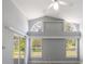Bright living room with vaulted ceiling, fan, and ample natural light through large windows and sliding glass door to the outside at 2767 Aragon Ter, Lake Mary, FL 32746
