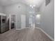 Open-concept living area with wood-look flooring and view to the front door and hallway at 2767 Aragon Ter, Lake Mary, FL 32746