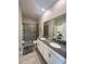 Bathroom featuring a double sink vanity, shower with glass door, and tiled floors at 2855 Bookmark Dr, Kissimmee, FL 34746