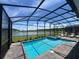 Screened-in pool and spa with tranquil lake views and a brick paver deck at 2855 Bookmark Dr, Kissimmee, FL 34746