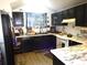 Modern kitchen with sleek black cabinetry, marble countertops, and updated appliances at 3017 Lambath Road, Orlando, FL 32818