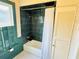 Cozy bathroom featuring a shower-tub combo with dark tiles and a white shower curtain at 311 W 10Th St, Sanford, FL 32771