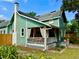 Charming two-story home with a covered porch, painted in a refreshing green with white trim and a striking brick chimney at 311 W 10Th St, Sanford, FL 32771