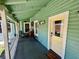 Inviting porch area with ample seating and a welcoming entrance with green paint and yellow door at 311 W 10Th St, Sanford, FL 32771