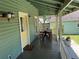 Picturesque porch with a dining table, seating and beautiful outdoor decor with green paint and yellow door at 311 W 10Th St, Sanford, FL 32771
