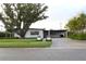 Charming single-story home with mature tree, carport, well-manicured lawn and lush landscaping at 319 Halsey St, Orlando, FL 32839