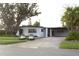 Charming single-story home with mature tree, carport, well-manicured lawn and lush landscaping at 319 Halsey St, Orlando, FL 32839